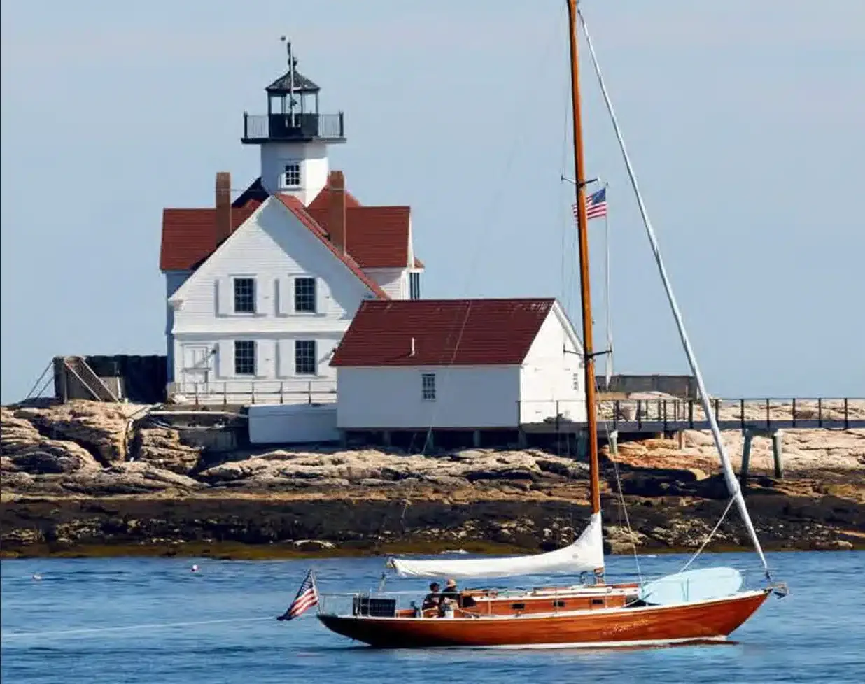 Lighthouse with sailboat in foreground