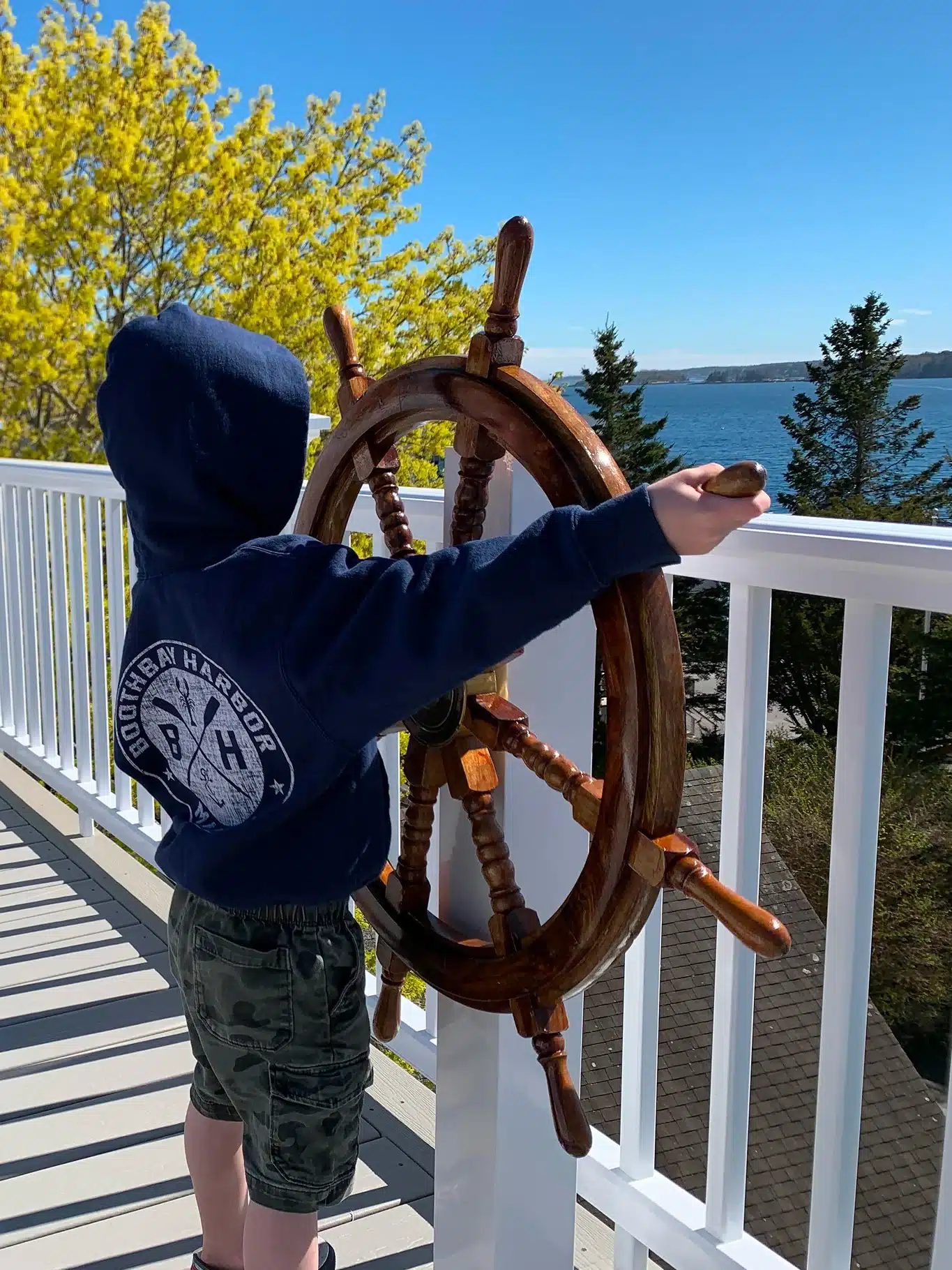 Child enjoying harbor views from the deck at The Helm House in Boothbay Harbor Maine