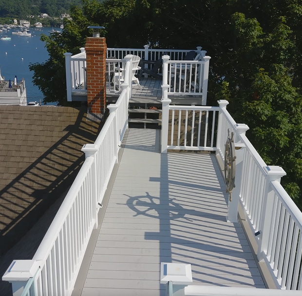 White deck overlooking water and trees